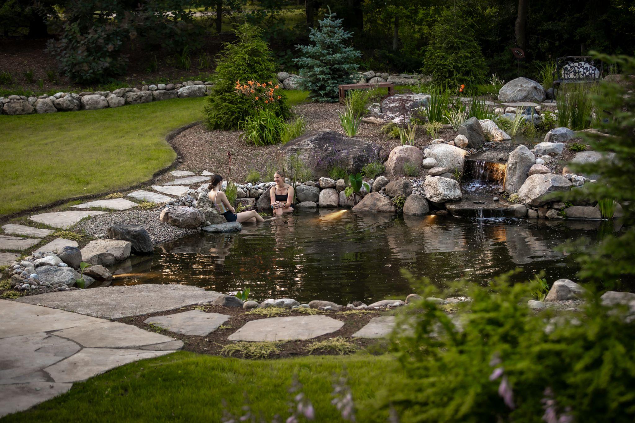 Natural swimming pond with seating and stone steps